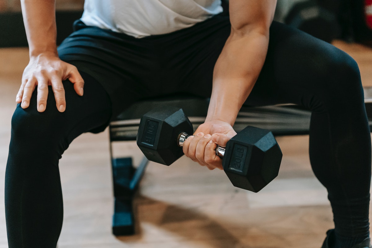 a man doing a bicep curl concentration close up dumbbell